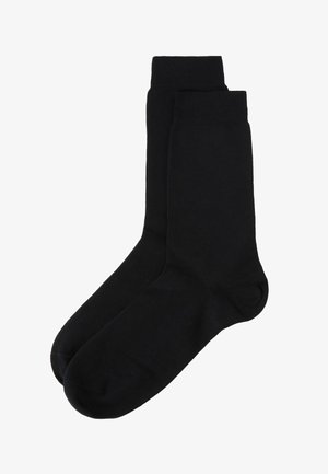 Sorte bomuldsokker med en glat tekstur, der har en ribbet kant og en standard længde. Usynlig tå og ensfarvet gennem hele sokken.