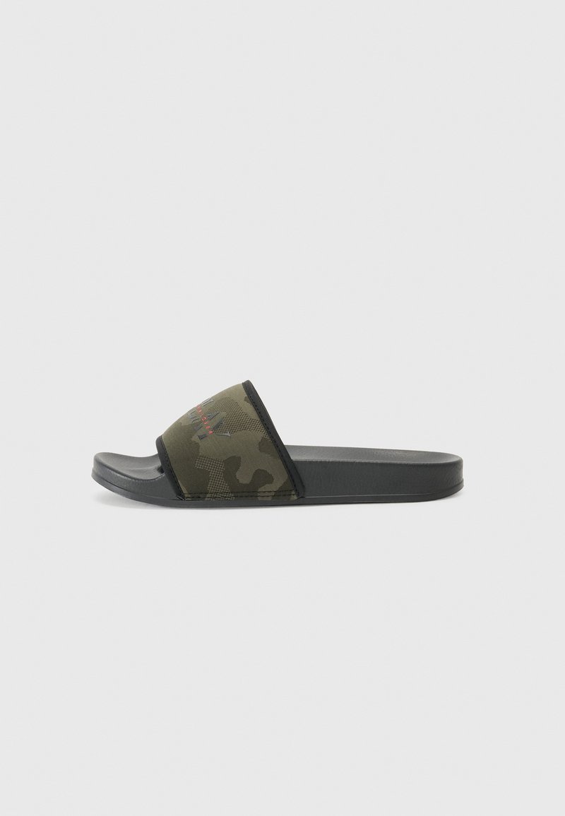 Pantoletten im Camouflage-Muster mit einer flexiblen schwarzen Gummisohle und einem weichen Stoffriemen, der eine strukturierte Oberfläche und ein Logodesign aufweist.