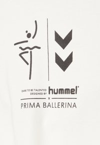 Hvidt stof med et sort grafisk design af en danser og to nedadgående pile. Teksten inkluderer "Dare to be Talented," "hummel," og "Prima Ballerina."
