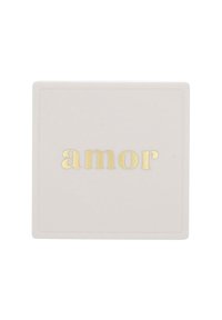 Fyrkantig keramikunderlägg i mjukt vitt, med ordet "amor" i prägling i gyllene bokstäver. Enkel design med subtil textur.