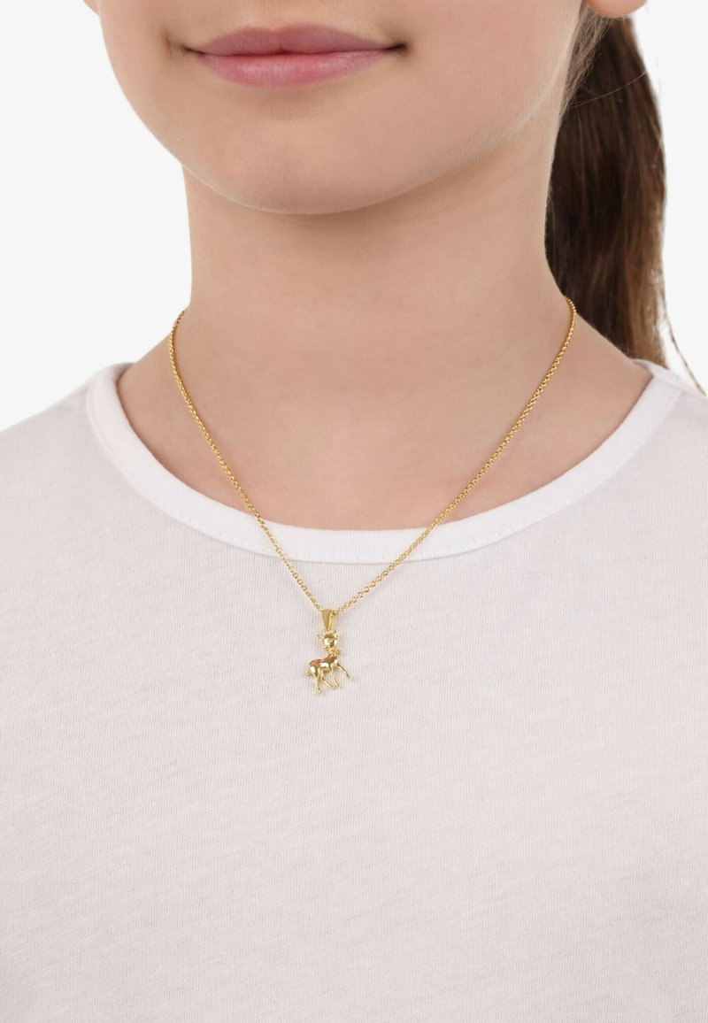 Collar de cadena de oro con un pequeño colgante de ciervo, llevado por una persona con una camisa blanca, que presenta un acabado suave y detalles intrincados.