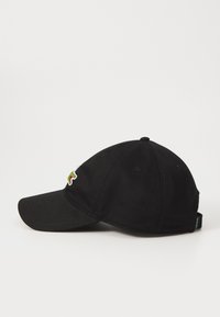 Fekete pamut baseball sapka ívelt szélekkel, hímzett logóval elöl, hat szellőzőlyukkal és állítható pánttal hátul.