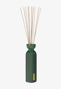 Diffuseur en céramique à rayures vert foncé avec des tiges en crème et un accent logo doré sur le côté. Forme de vase haute et étroite.