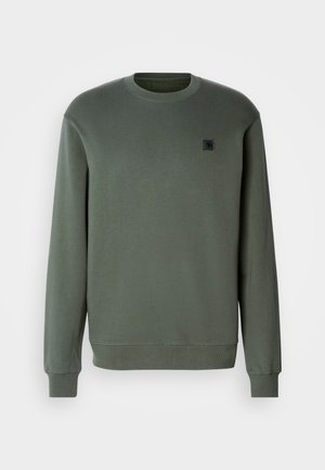 Olivgrüner Pullover aus Baumwollmischung, Rundhalsausschnitt, lange Ärmel, gerippte Bündchen und Saum, versehen mit einem kleinen schwarzen Logo-Patch auf der Brust.