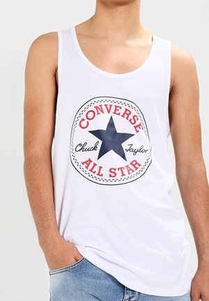 Débardeur blanc avec un motif rond comportant un texte rouge et une étoile marine, intitulé "CONVERSE Chuck Taylor ALL STAR." Tissu en coton lisse.