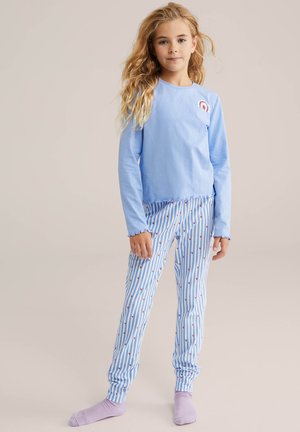 Világoskék hosszú ujjú felső szivárvány grafikával, hozzá társítva kék-fehér csíkos nadrág apró piros szív mintákkal.