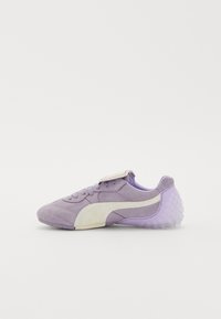 Purple athletic shoe featuring a textured upper, white side stripe, and a translucent rubber sole with a round pattern. Lace-up design.