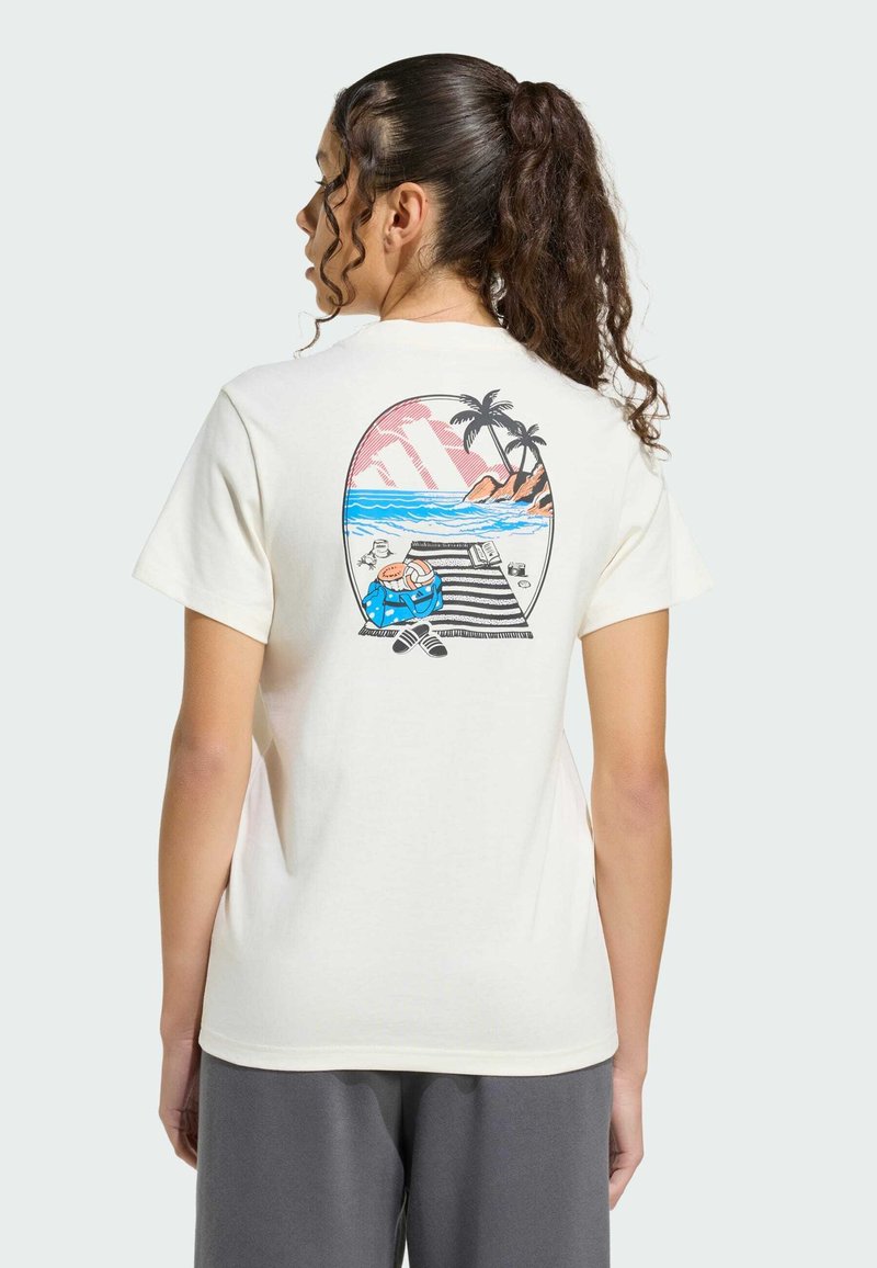 Camiseta de algodón color crema con un gráfico colorido de playa en la parte trasera, que incluye palmeras, olas y una figura descansando sobre una esterilla a rayas.