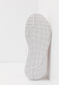 Suela de zapato en goma blanca con surcos y patrones texturizados, diseñada para tracción. Presenta bordes redondeados y un diseño minimalista.