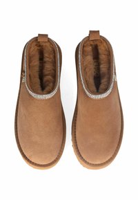 Stivaletti alla caviglia in suede marrone con una morbida fodera in pelliccia, arricchiti da un bordo in strass intorno al colletto. Suola in gomma piatta.