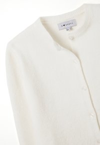 Cardigan bianco realizzato in morbido materiale testurizzato. Presenta un collo rotondo, bottoni frontali e un'etichetta con "B ♥ ANGEL" cucita all'interno.