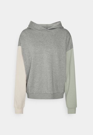 Sudadera gris claro con una manga izquierda beige claro y una manga derecha verde pálido, con puños acanalados y una cinturilla ajustada.