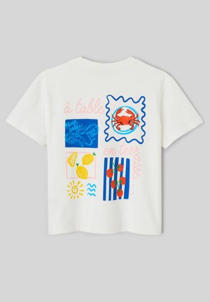 T-shirt blanc avec des illustrations colorées d'aliments comprenant un crabe, des crevettes, des citrons, des tomates et un soleil, avec un texte en français.