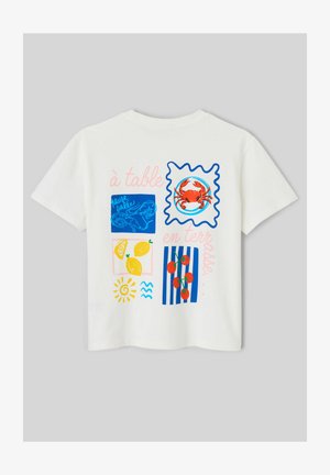 T-shirt blanc avec des illustrations colorées d'aliments comprenant un crabe, des crevettes, des citrons, des tomates et un soleil, avec un texte en français.