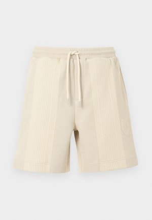 Μπεζ σορτς με ριμπ ύφασμα, ελαστική μέση με κορδόνι και λογότυπο στο κάτω μέρος της πλευράς.