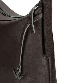 Hnědá kožená kabelka přes rameno s texturovaným povrchem, vybavená šedým akcentovým popruhem a černým kovovým logem. Horní zapínání na zip.