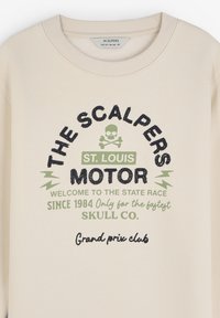 Beige sweatshirt med rund hals, broderet "THE SCALPERS MOTOR" logo, grønne detaljer og et kraniedesign.