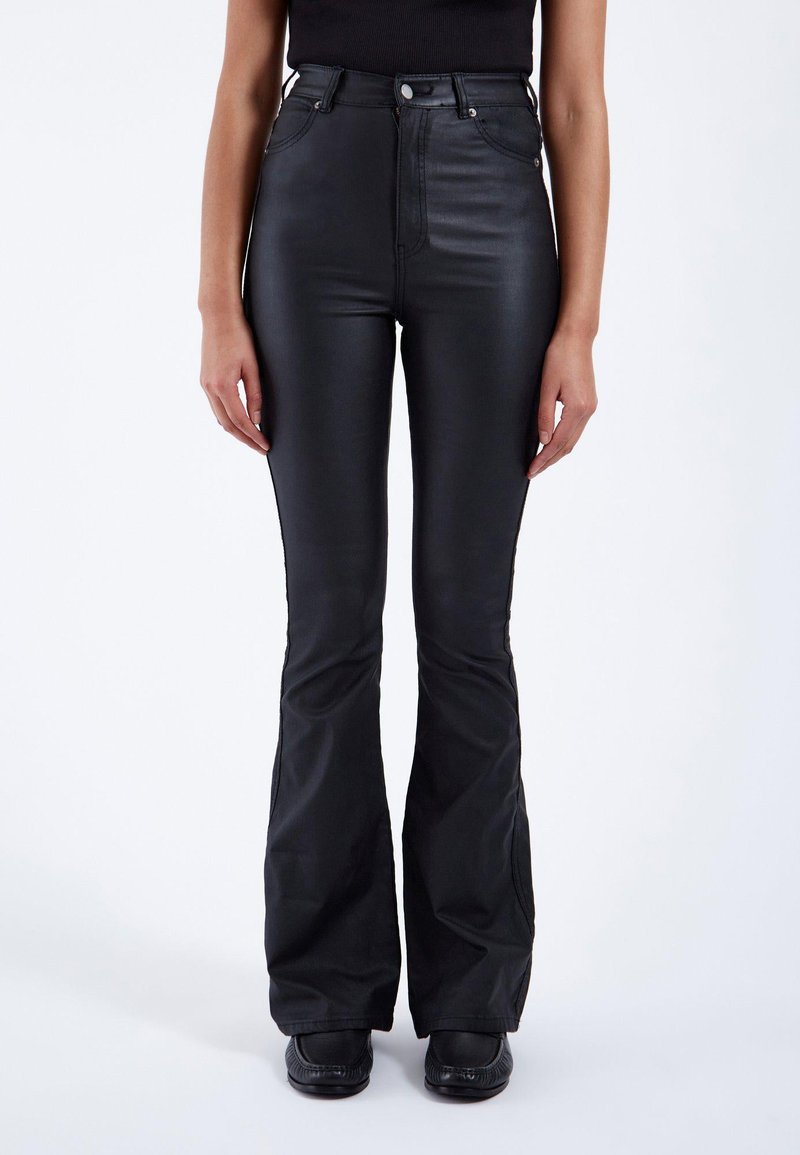 Hoge taille zwarte flared broek van glanzend materiaal, met een ritssluiting aan de voorkant, twee zakken en een aansluitend ontwerp op de bovenbenen.