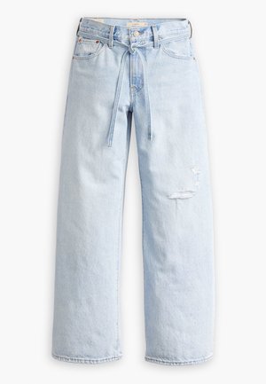 Jean large bleu clair avec une ceinture en denim intégrée nouée en nœud et des détails délavés sur la cuisse droite.