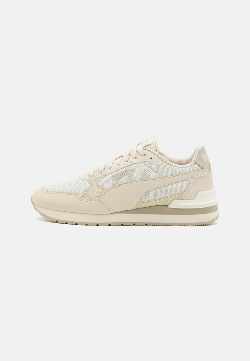 Vaaleanbeige lenkkarit, joissa on yhdistelmä teksturoitua nahkaa ja verkkomateriaaleja. Varustettu valkoisella välikohdalla ja hienovaraisilla brändäyskoristuksilla. Klassinen nauhakiinnitys.