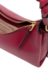 Borsa a tracolla in pelle rossa con zipper dorato, caratterizzata da una superficie texturizzata e una foderatura liscia. Include un piccolo tag in pelle all'interno.