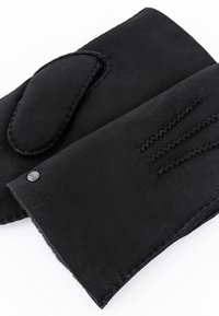 Schwarze Lederhandschuhe ohne Finger mit weicher Textur, die einen teilweise bedeckten Daumen, eine ordentliche Naht und ein kleines Metallelement aufweisen.