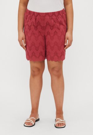 Rode scalloped shorts met een kantpatroon en een elastische tailleband, met een relaxte pasvorm. Gecombineerd met witte sandalen.