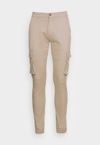Beige cargobyxor i bomull med slim fit, med flera fickor och avsmalnande anklar, designade för funktion och komfort.