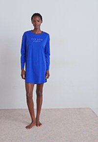 Vestido azul de manga longa, feito de um tecido macio, com uma gráfica das fases da lua centrada no peito, um corte relaxado e comprimento até meio da coxa.