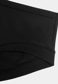 Biancheria intima in cotone nera con una texture liscia, dotata di una vita estesa e dettagli di cucitura minimi. Design semplice e funzionale.