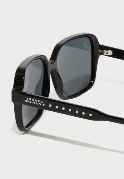 Óculos de sol pretos com armação retangular, lentes cinzas e hastes decorativas com padrão que apresentam o nome da marca "ISABEL MARANT."