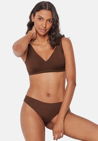 Set di reggiseno e slip marrone realizzato in morbido tessuto, con un design a scollo profondo a V e spalline larghe per un sostegno ottimale, dal texture liscia e con cuciture minime.