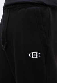 Μαύρα παντελόνια φόρμας Under Armour με πλαϊνή τσέπη και ορατή ελαστική μέση με κορδόνι.