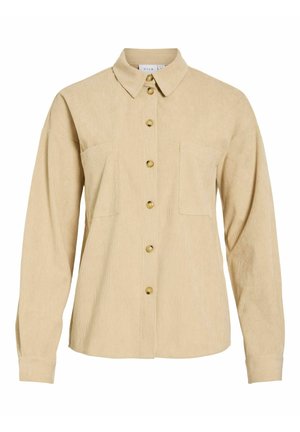 Chemise beige en velours côtelé à boutons, manches longues, deux poches poitrine et col classique.