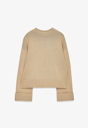 Beige kudumine sall, millel on soonikuline ümar kaelus, mansetid ja alläär, pikkaevarakud ja veidi üle mõõtme sobivus.