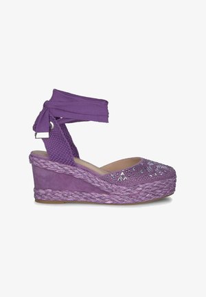 Paarse espadrille wedge schoen met een textiele bovenkant, gevlochten jute zool en decoratieve rhinestone accenten op het teengebied.