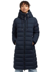 Lång marinblå pufferjacka med huva, med dragkedja fram, quiltad stoppning och två sidofickor. Mjuk textur och elegant design.