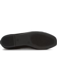 Suela de zapato de ante negro con una superficie lisa, patrón de tracción de goma y un ligero tacón. Marcas y etiqueta de tamaño visibles en la suela.