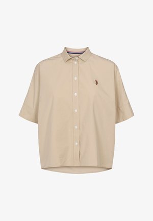 Beżowa koszula z krótkim rękawem i kołnierzykiem na guziki. Posiada subtelne haftowane logo na piersi oraz zaokrąglony dół. Gładka struktura tkaniny.