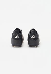 Black cleats with a textured upper, featuring a smooth heel, three white stripes logo, and conical studs on a dark sole.