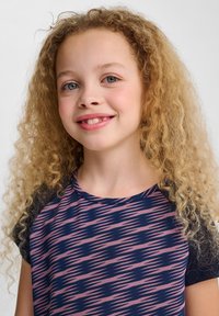 Kortärmad skjorta med marinblå bas och rosa zigzag-mönster, rund halsringning och svarta ärmar. Mjuk, texturerad tyg med avslappnad passform.