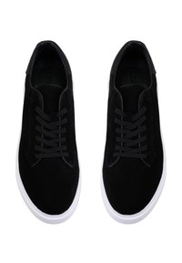 Schwarze Wildleder-Sneaker mit flachen schwarzen Schnürsenkeln und einer weißen Gummisohle. Sie verfügen über ein glattes Obermaterial und ein abgerundetes Design der Zehenpartie.