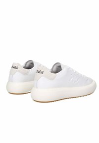 Sneakers bianchi con tomaia in pelle liscia, accenti in suede beige e una suola in gomma spessa e testurizzata. Presentano il logo sul tallone.