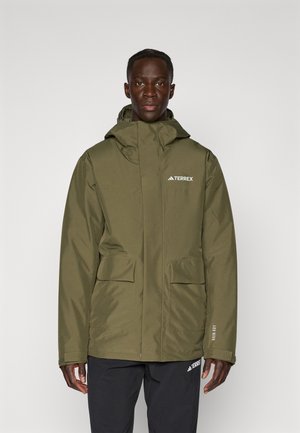Veste imperméable vert olive avec capuche, poches avant et logo blanc sur la poitrine. Texture lisse et design fonctionnel pour une utilisation en extérieur.