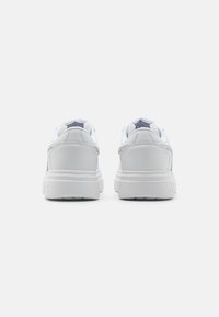 Scarpe sportive bianche con tomaia in pelle liscia, colletto imbottito, dettagli riflettenti e suola ammortizzata con grip testurizzato.