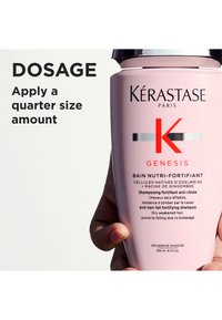 Kérastase Genesis Bain Nutri-Fortifiant sjampoflaske, rosa plast, rund form, svart lokk, med stor svart og rød tekst som beskriver bruksanvisning.
