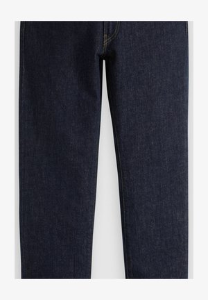 Donkere blauwe spijkerbroek met rechte pijpen en zichtbare gele stiknaden langs de naden en zakken.