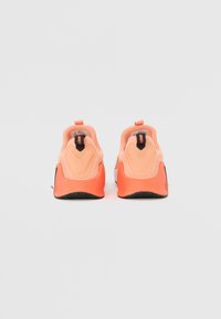 Scarpe da ginnastica color pesca con tomaia in tessuto liscio, linguetta per facilitare la calzata e suola in gomma nera. Accenti dal design curvo sul tallone migliorano la struttura.