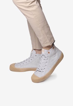 Zapatillas altas de lona en gris claro con suelas de goma beige, con diseño de cordones y punteras reforzadas.