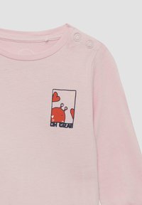 Roze long-sleeve T-shirt met een grafische afbeelding van een lachende rode krab op de linkerkant van de borst, omringd door harten en de tekst "OH CRAB." Voorzien van schouderdrukknopen.